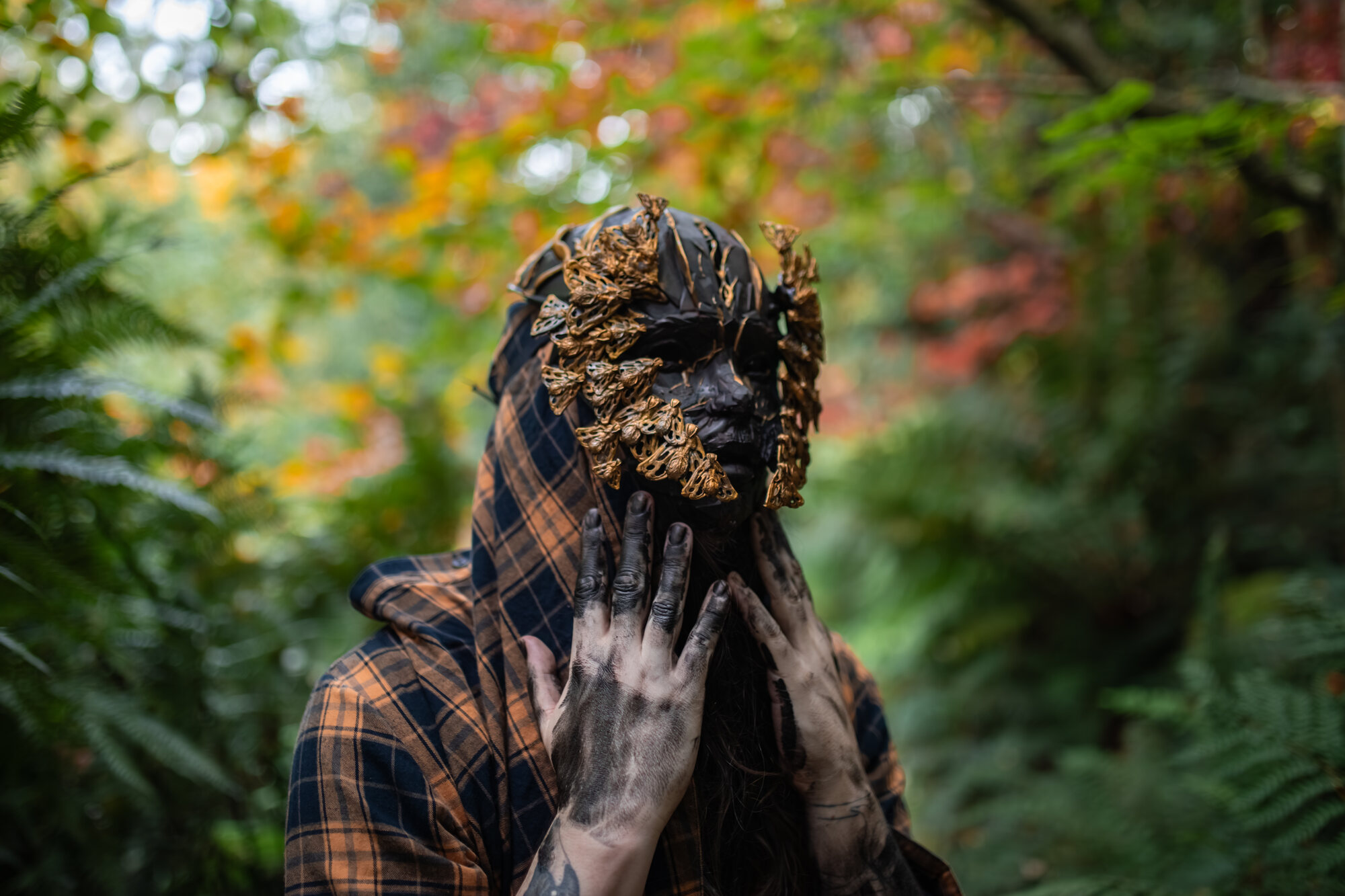 Wearable mask, gold butterfly motifs, forest setting